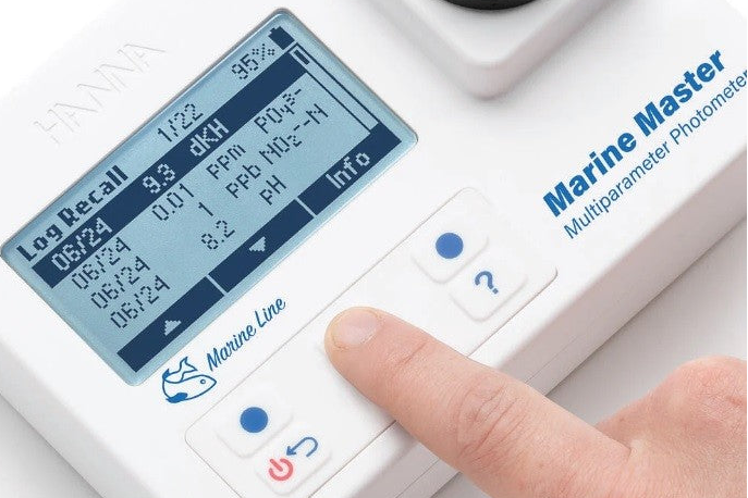 Marine Master Multiparameter Photometer with digital display and hand interacting with it